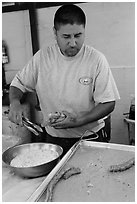 Man coating churros in sugar. Baja California, Mexico (black and white)