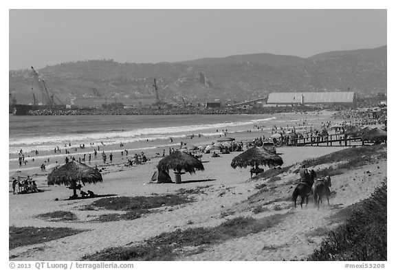 Beach with shade palapas and horseman, Ensenada. Baja California, Mexico