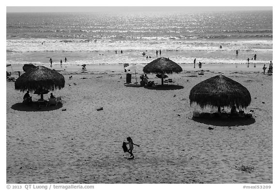 Straw sun shelter umbrellas and ocean, Ensenada. Baja California, Mexico (black and white)