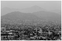 Distant view of Ensendada spreading up hills at sunset. Baja California, Mexico (black and white)