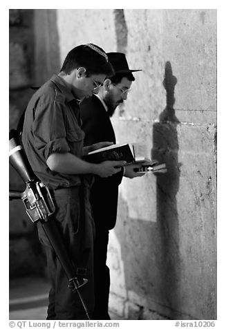 Young soldier and orthodox jew reading prayer  books at the Western Wall. Jerusalem, Israel (black and white)