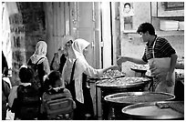 Muslem women purchasing sweets. Jerusalem, Israel (black and white)