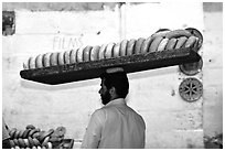 Man carrying many loafes of bread on his head. Jerusalem, Israel ( black and white)