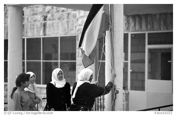 Women raise the Palestian flag at a school in East Jerusalem. Jerusalem, Israel (black and white)