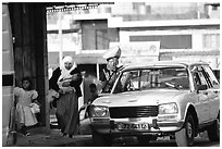 Women next to an old French Peugeot car, Hebron. West Bank, Occupied Territories (Israel) ( black and white)