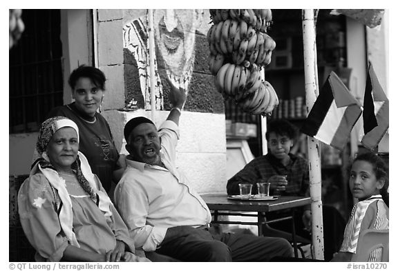 Palestinian head of family  pointing  to a mural of Yasser Arafat, Jericho. West Bank, Occupied Territories (Israel)