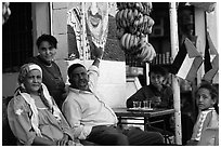 Palestinian head of family  pointing  to a mural of Yasser Arafat, Jericho. West Bank, Occupied Territories (Israel) (black and white)