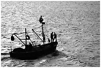 Small fishing boat silhouetted, late afternoon, Akko (Acre). Israel (black and white)