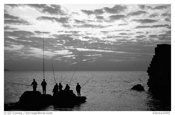 Fishermen standing on a rock, Akko (Acre). Israel (black and white)
