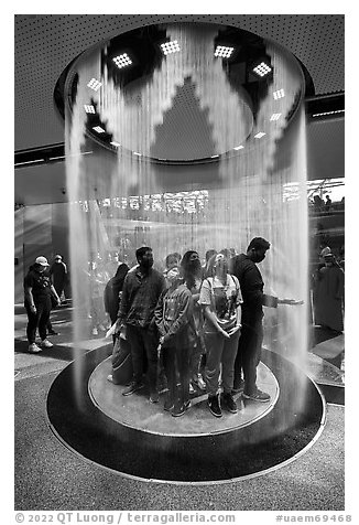 Visitors behind curtain of water, Saudi Arabia Pavilion. Expo 2020, Dubai, United Arab Emirates (black and white)