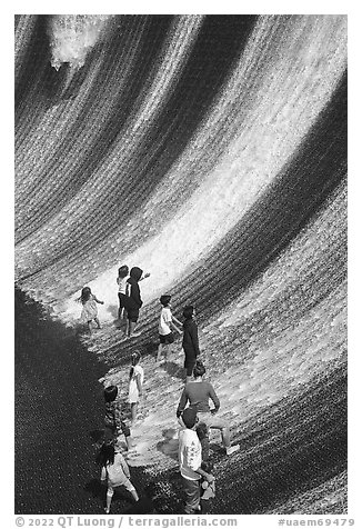 Visitors interacting with water feature. Expo 2020, Dubai, United Arab Emirates (black and white)