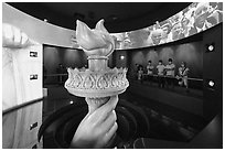 Visitors look at replica of Statue of Liberty torch, USA Pavilion. Expo 2020, Dubai, United Arab Emirates ( black and white)