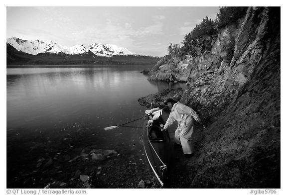 Kayaker pulling on shore at midnight, Muir Inlet. Glacier Bay National Park, Alaska