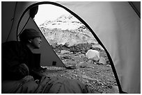 Visitor in  tent looking outside to Lamplugh Glacier. Glacier Bay National Park, Alaska (black and white)