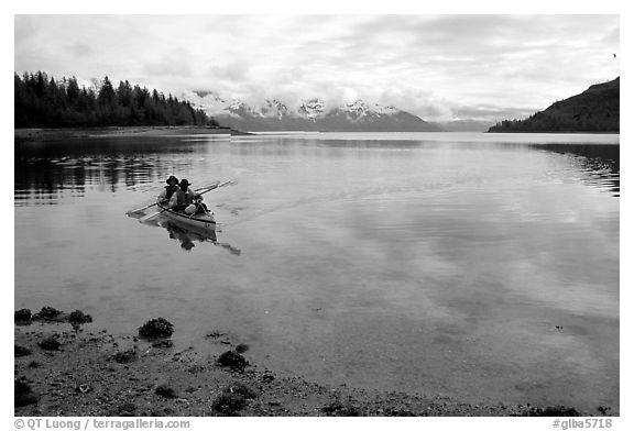 Kayakers paddle a double kayak in Hugh Miller Inlet. Glacier Bay National Park, Alaska