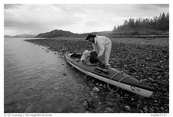 Kayaker unloading gear from a double kayak. Glacier Bay National Park, Alaska