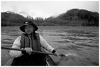 Kayaker paddling away from shore in Muir Inlet. Glacier Bay National Park, Alaska (black and white)