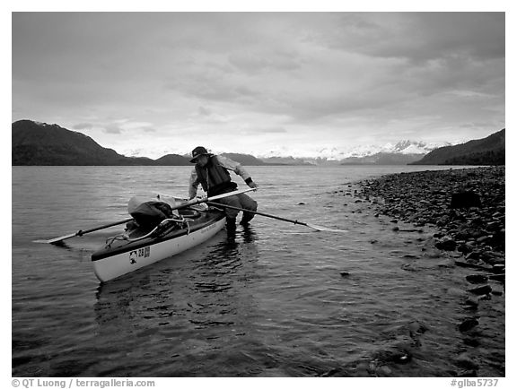 Kayaker getting into the kayak,  Muir Inlet. Glacier Bay National Park, Alaska