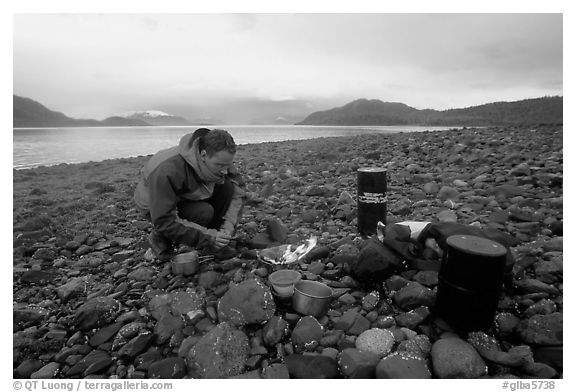 Kayaker firing up the stove,  Muir Inlet. Glacier Bay National Park, Alaska