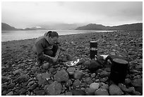 Kayaker firing up the stove,  Muir Inlet. Glacier Bay National Park, Alaska (black and white)
