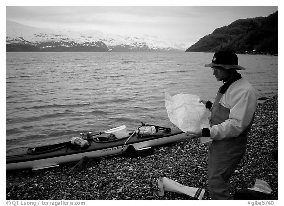 Kayaker looking at the map, East Arm. Glacier Bay National Park, Alaska