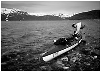 Kayaker tying up gear on top of the kayak,  East Arm. Glacier Bay National Park, Alaska (black and white)