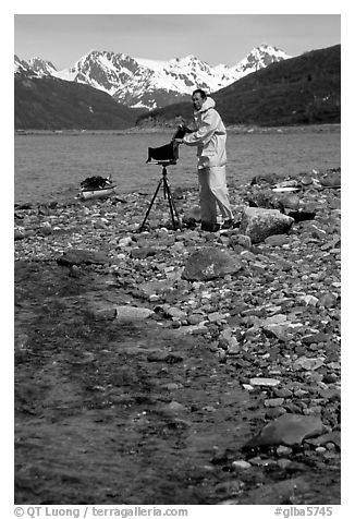 Large format photographer wearing kayaking gear on a beach in East Arm. Glacier Bay National Park, Alaska