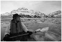 Kayaker pausing amongst icebergs near John Hopkins Inlet. Glacier Bay National Park, Alaska (black and white)