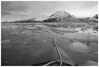 Kayak's prow, floating icebergs, and glacier. Glacier Bay National Park, Alaska (black and white)