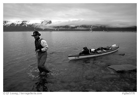 Kayaker towing kayak, East arm. Glacier Bay National Park, Alaska