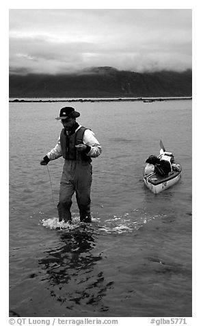 Kayaker towing kayak, East arm. Glacier Bay National Park, Alaska