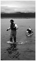 Kayaker towing kayak, East arm. Glacier Bay National Park, Alaska (black and white)