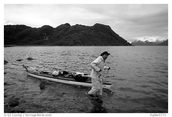 Kayaker towing kayak, East arm. Glacier Bay National Park, Alaska