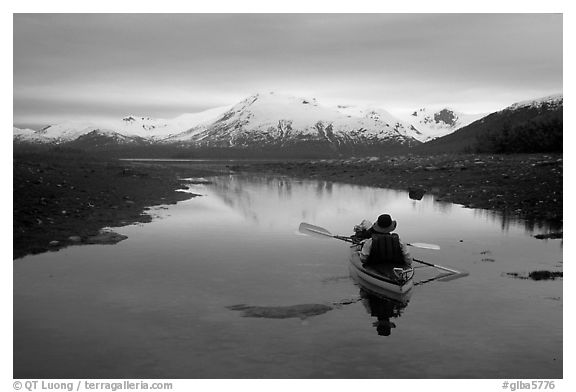 Kayaker paddles in  a shallow tidal channel into Scidmore Bay. Glacier Bay National Park, Alaska