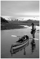 Kayaker standing in Scidmore Bay next to a shallow tidal channel. Glacier Bay National Park, Alaska (black and white)