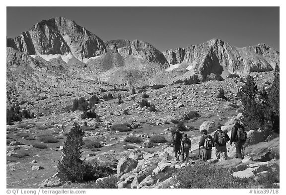 Hikers on alpine terrain and Mt Giraud range, Dusy Basin. Kings Canyon National Park, California