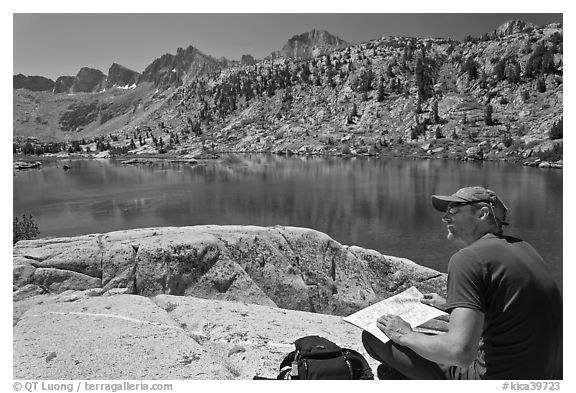 Hiker with map near lake, lower Dusy Basin. Kings Canyon National Park, California