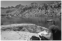 Hiker with map near lake, lower Dusy Basin. Kings Canyon National Park, California (black and white)