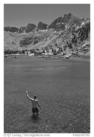 Man standing in alpine lake, lower Dusy Basin. Kings Canyon National Park, California