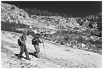 Father and son hiking on granite slab, Le Conte Canyon. Kings Canyon National Park, California (black and white)