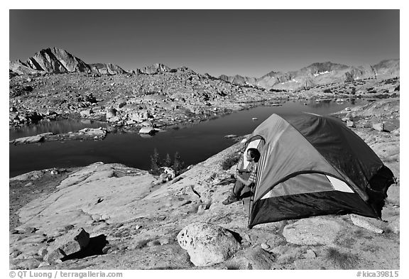 Man sitting in tent above lake, Dusy Basin. Kings Canyon National Park (black and white)