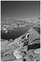 Man looking out from tent above lake, morning, Dusy Basin. Kings Canyon National Park, California (black and white)