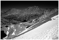 Backpackers on a snow field at a high pass. Kings Canyon National Park, California (black and white)