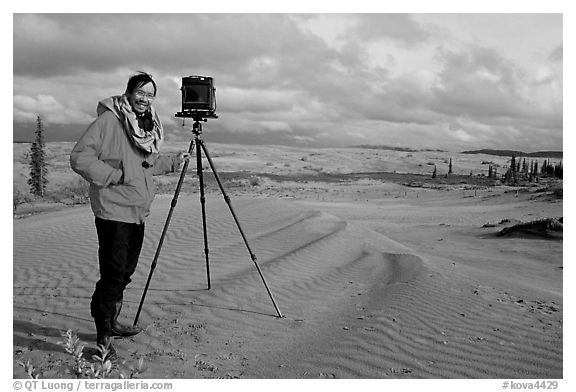 Large format photographer with camera on Kobuk Dunes. Kobuk Valley National Park, Alaska