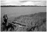 Canoeist deflating the canoe. Kobuk Valley National Park, Alaska (black and white)