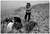 Canoeist standing next to gear and deflated and folded  canoe. Kobuk Valley National Park, Alaska (black and white)