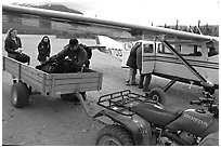 Unloading the gear from the plane to a trailer on the Port Alsworth airstrip. Lake Clark National Park, Alaska (black and white)