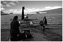 Pilot unloading a backpack from the floatplane on Lake Turquoise. Lake Clark National Park, Alaska (black and white)