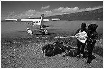 Backpackers dropped off by floatplane on Lake Turquoise orient themselves on the map. Lake Clark National Park, Alaska (black and white)