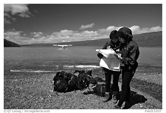 Backpackers orient themselves on the map while the plane is taking off. Lake Clark National Park, Alaska